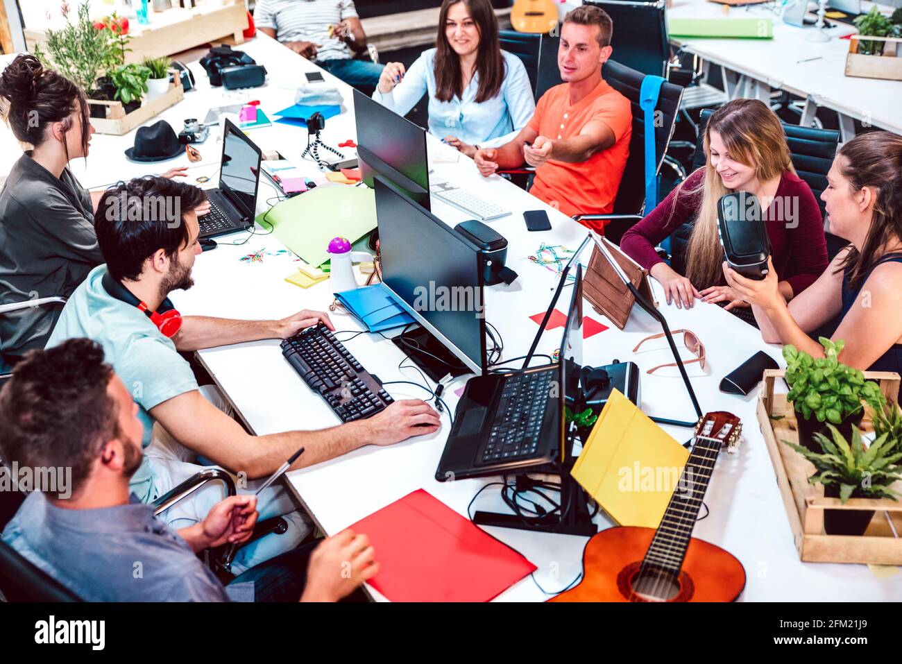 Giovani lavoratori dipendenti su computer in uno studio urbano alternativo - risorse umane e concetto di business nello spazio di lavoro congiunto Foto Stock