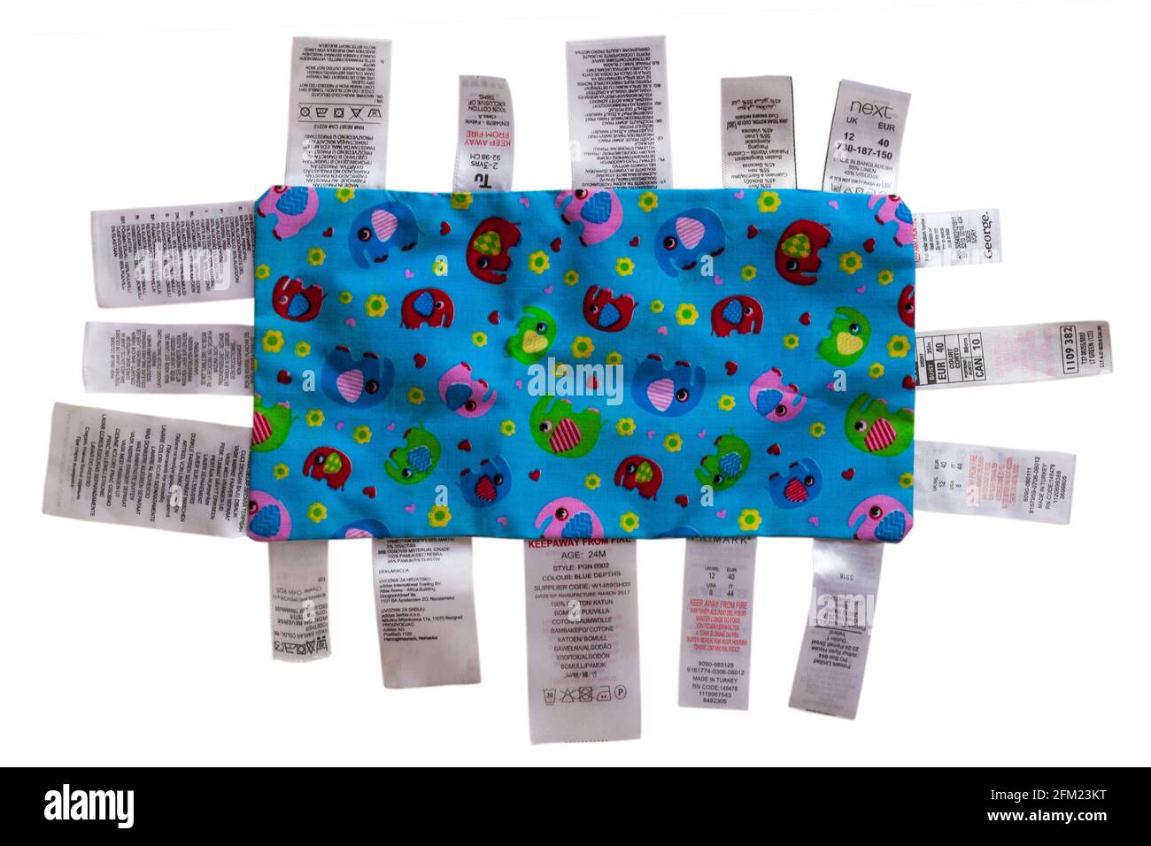 Varie etichette cucite intorno al pezzo di tessuto in molte lingue diverse, multilingue isolato su sfondo bianco Foto Stock