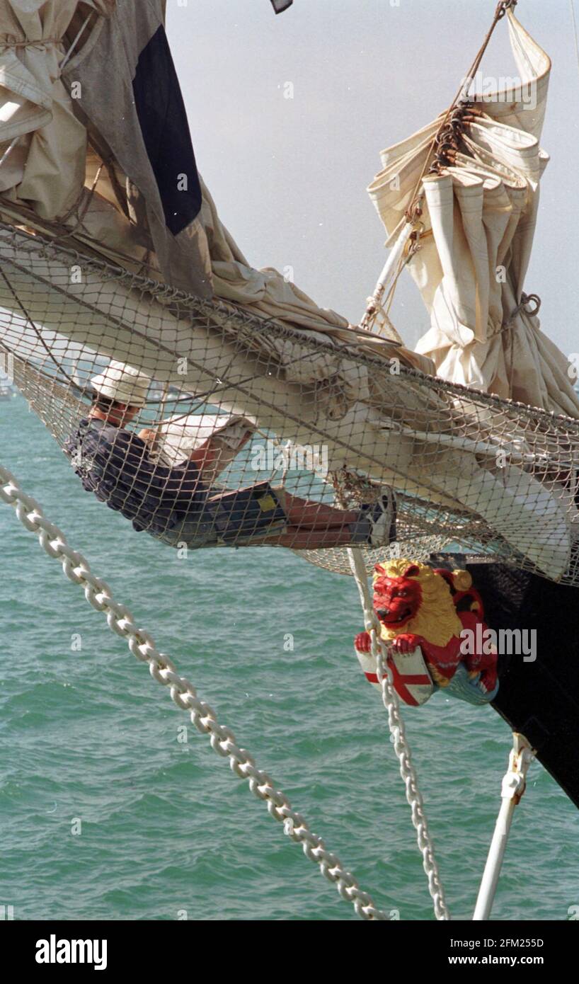 UN MEMBRO DELL'EQUIPAGGIO TROVA UN POSTO TRANQUILLO PER UNA LETTURA A BORDO DELLA NAVE DI ADDESTRAMENTO VELICO WINSTON CHURCHILL AL FESTIVAL INTERNAZIONALE DEL MARE A POPPRTSMOUTH. PIC MIKE WALKER, 1998 Foto Stock