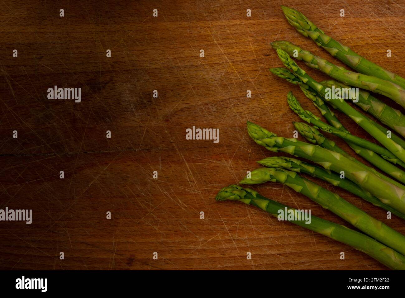 Lancia di asparagi su legno tritare sfondo. Sano concetto di mangiare. Foto Stock