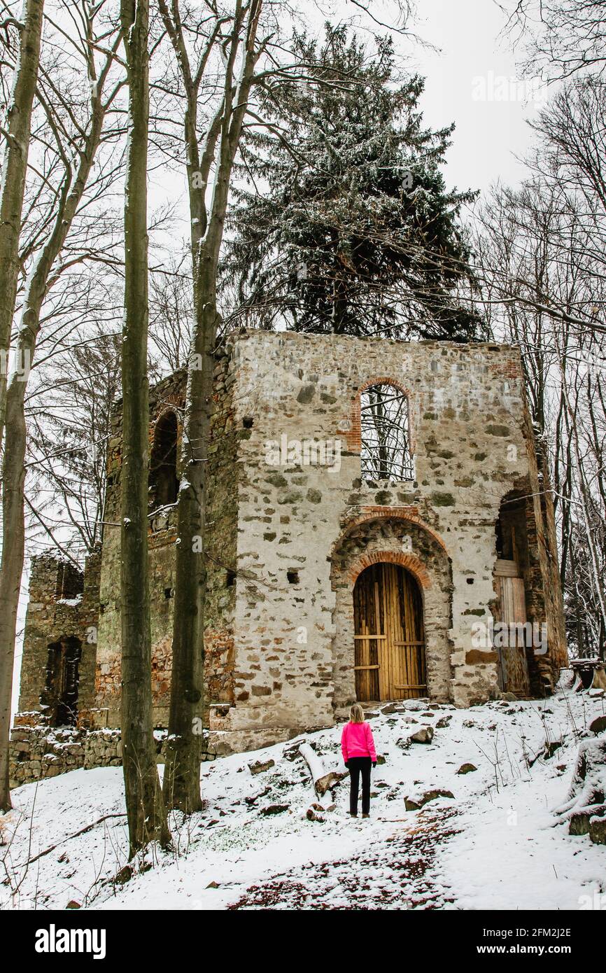 Ragazza escursionistica godendo di vista delle rovine di abbandonata Cappella di Santa Maria Maddalena sulla collina di Maly Blanik, Boemia centrale, ceco Republic.pellegrinaggio Foto Stock