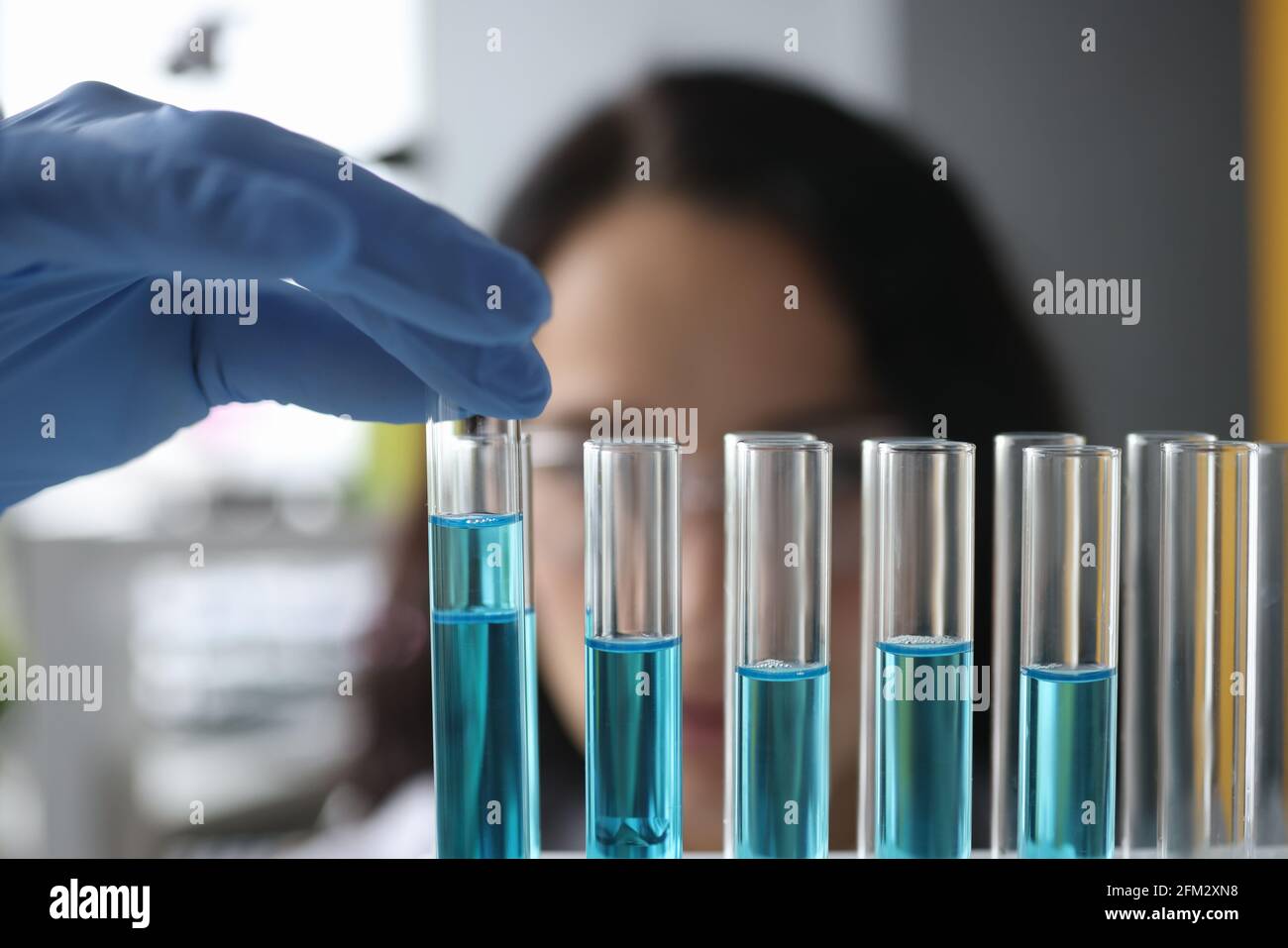 Provette per analisi chimiche con liquido blu in laboratorio Foto Stock