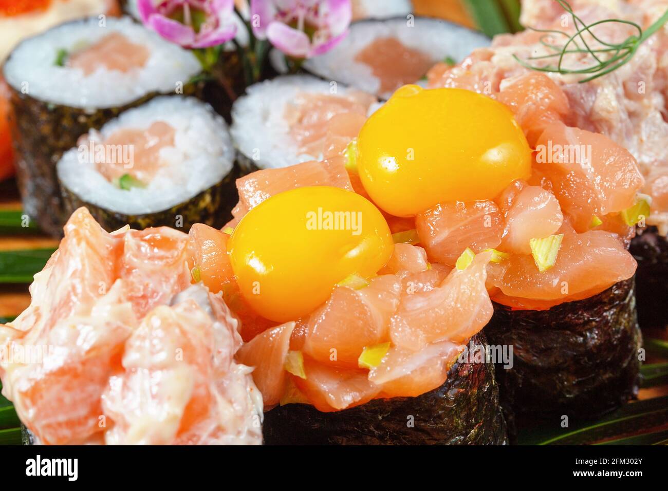 Sushi e panini con pesce rosso e uova di quaglia crude. Frammento Foto Stock