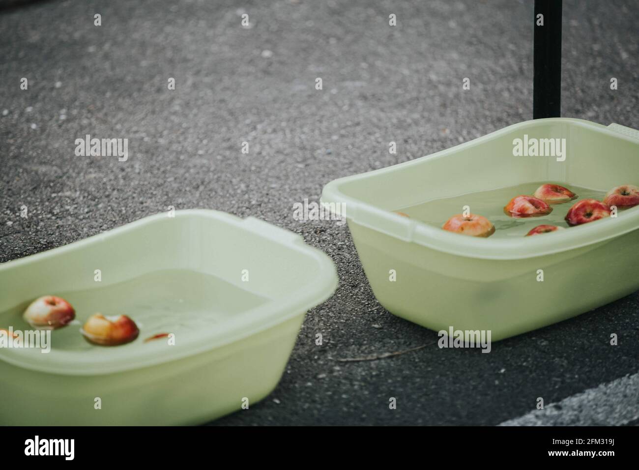 Vaschette di plastica riempite con acqua e mele lavate in loro Foto Stock