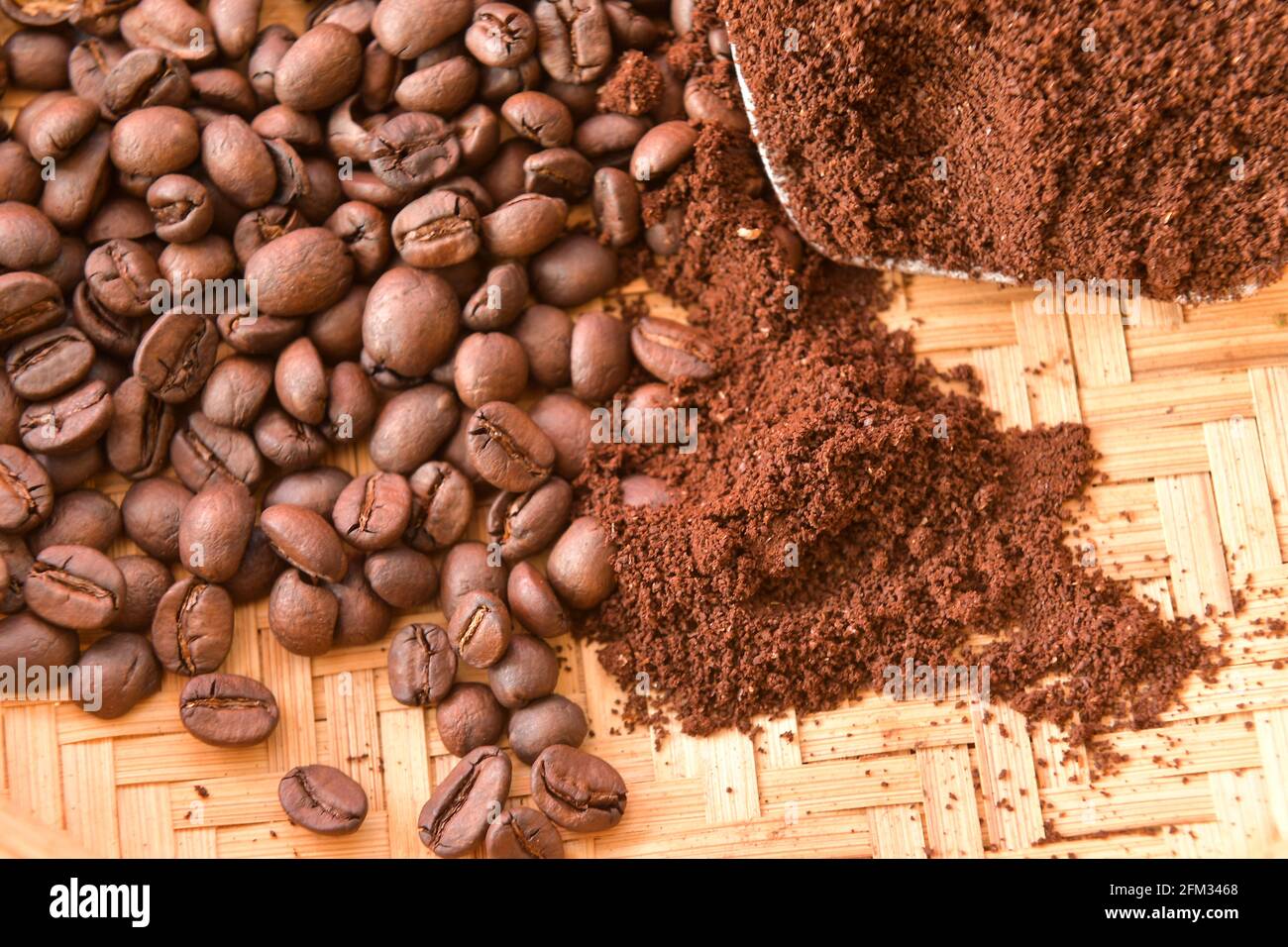 Caffè arrosto in grani e caffè macinato su un vassoio di bambù Foto Stock