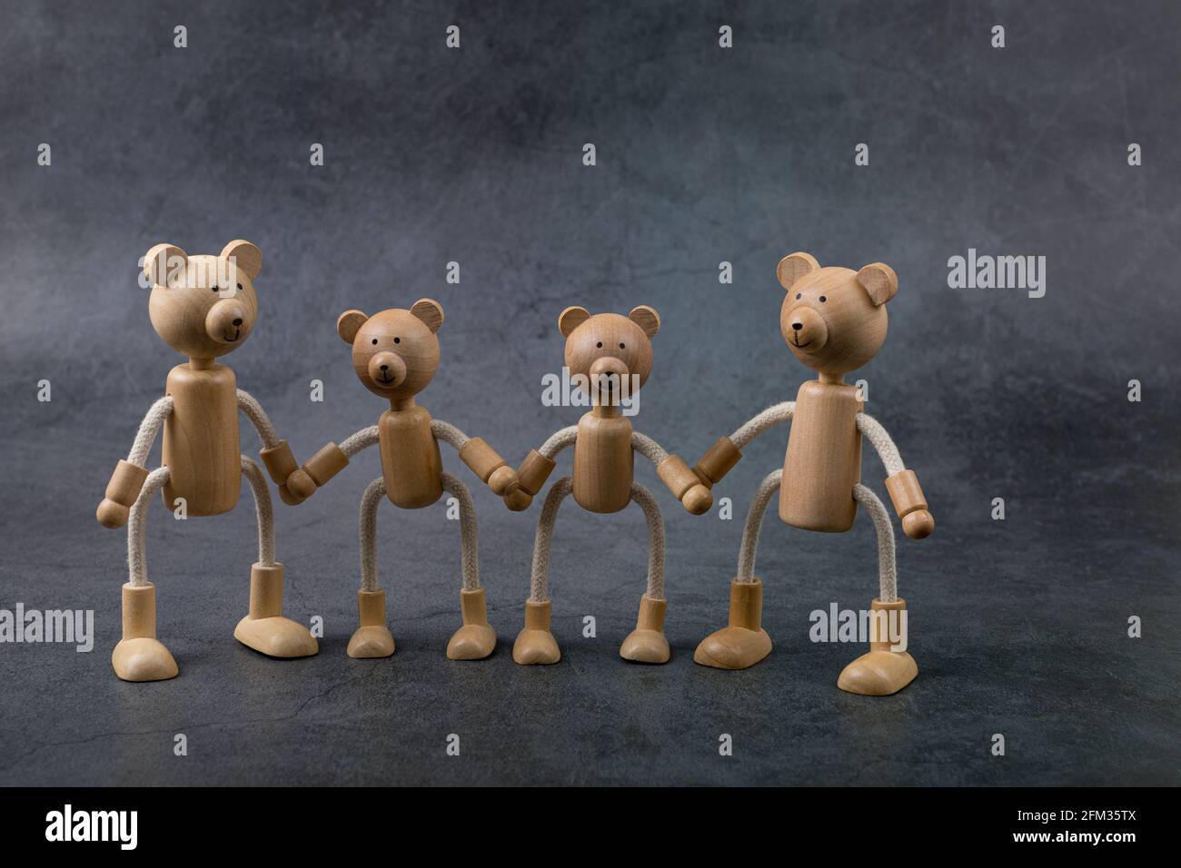 Concetto di giorno del padre felice. Biglietto d'auguri con famiglia di orsi giocattolo in legno su sfondo scuro. Spazio di copia. Foto Stock