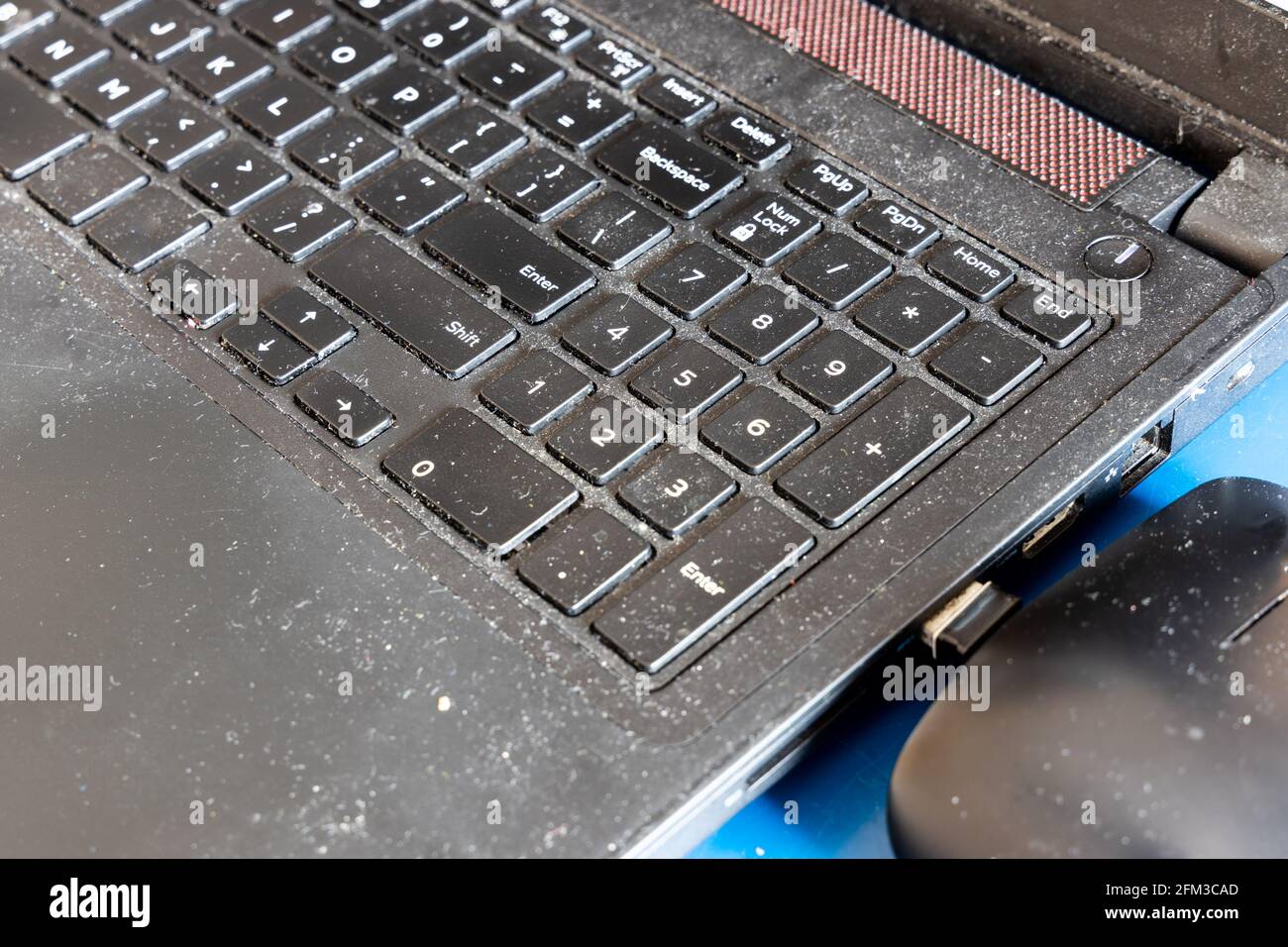 Primo piano sulla tastiera del computer laptop sporca e poco igienica, piena di polvere e particelle Foto Stock