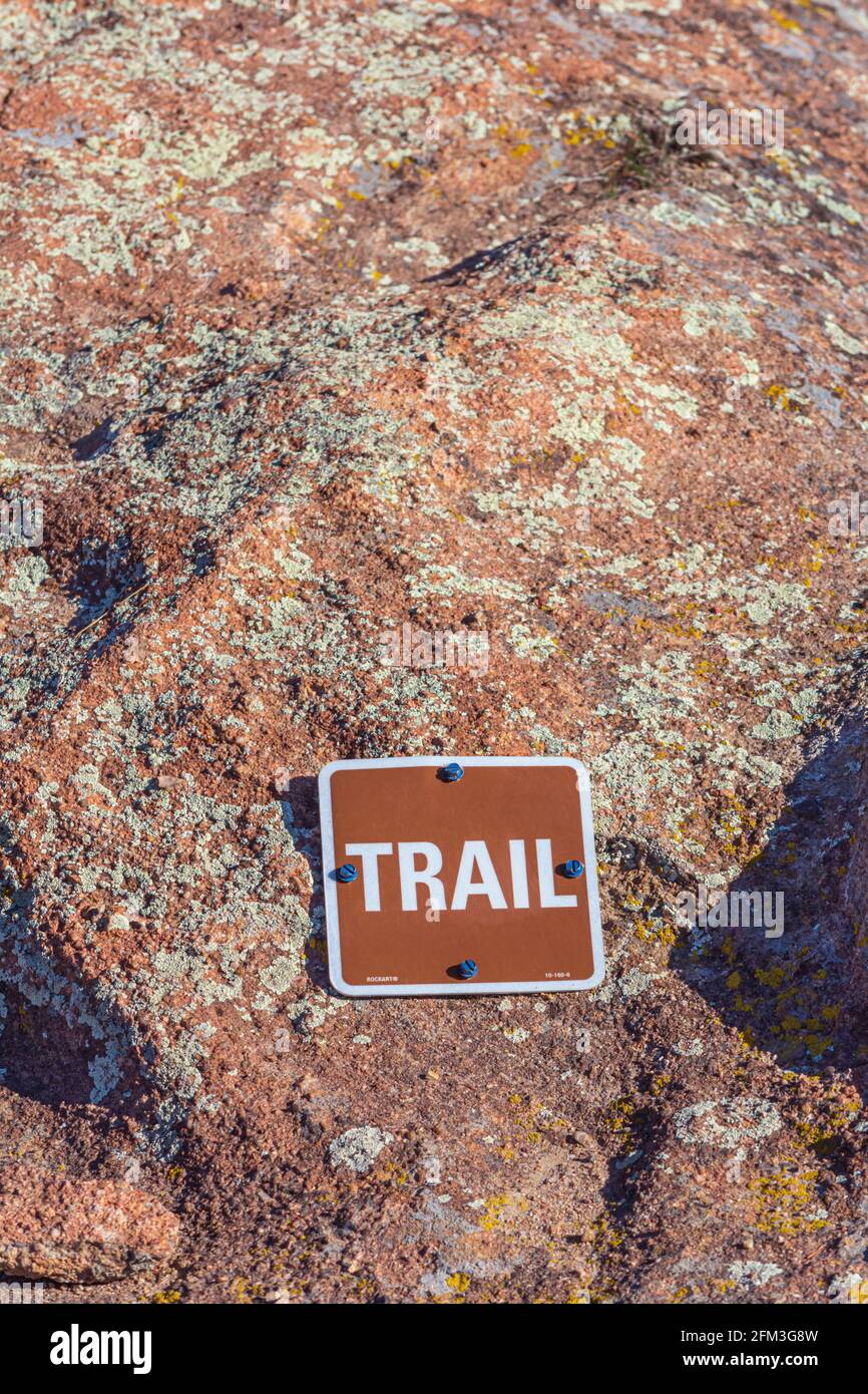 Segnavia che identifica dove il sentiero passa sopra pietra arenaria solida e roccia di lichen, Gateway Mesa Open Space Park, Colorado USA. Foto scattata in aprile. Foto Stock
