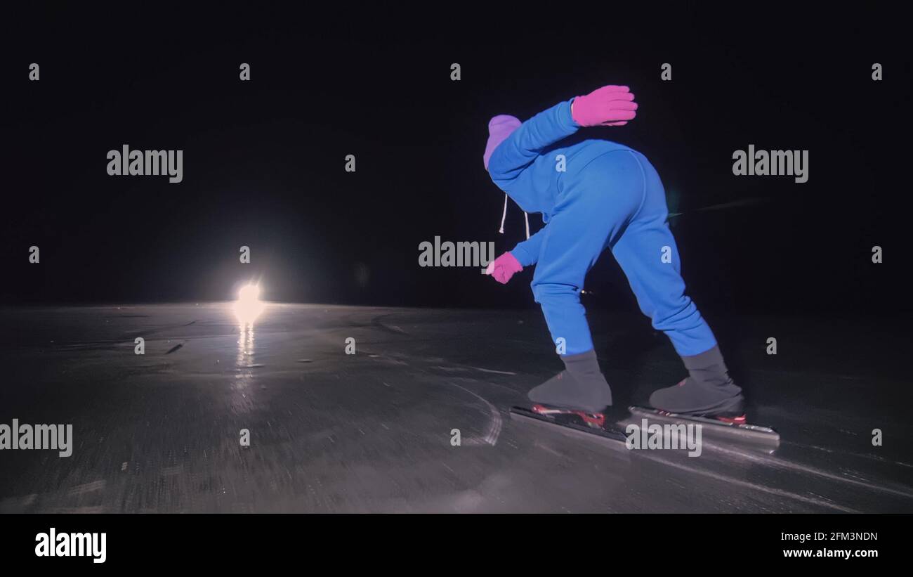 Il bambino allenarsi sul pattinaggio di velocità sul ghiaccio. Il  pattinaggio notturno. La ragazza pattina in inverno con abbigliamento  sportivo, occhiali sportivi. Slow motion all'aperto Foto stock - Alamy