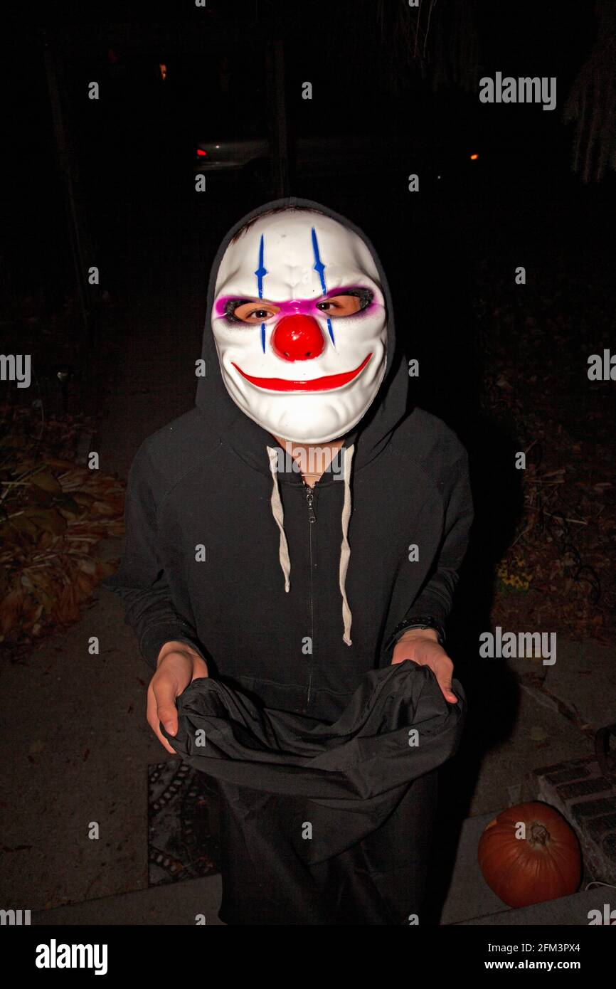 Trucco o treater di Halloween in costume che indossa la maschera di scherzo. St Paul Minnesota, Minnesota, Stati Uniti Foto Stock