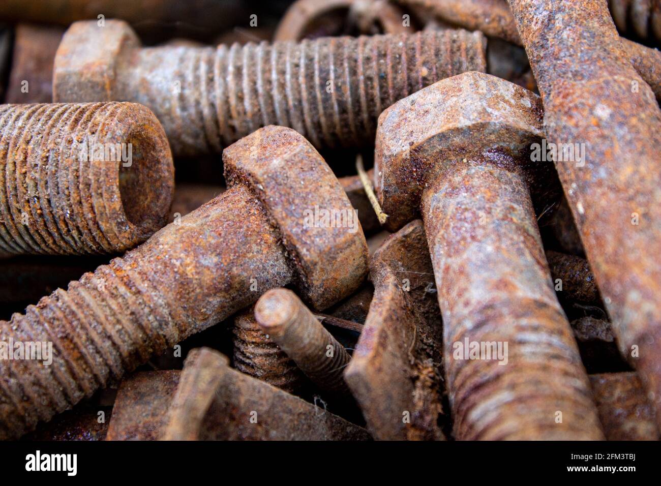 Vecchi bulloni e dadi arrugginiti. Dispositivi di fissaggio sulla lattoniera. I bulloni in ferro sono arrugginiti. Corrosione del metallo sulle viti. Foto Stock