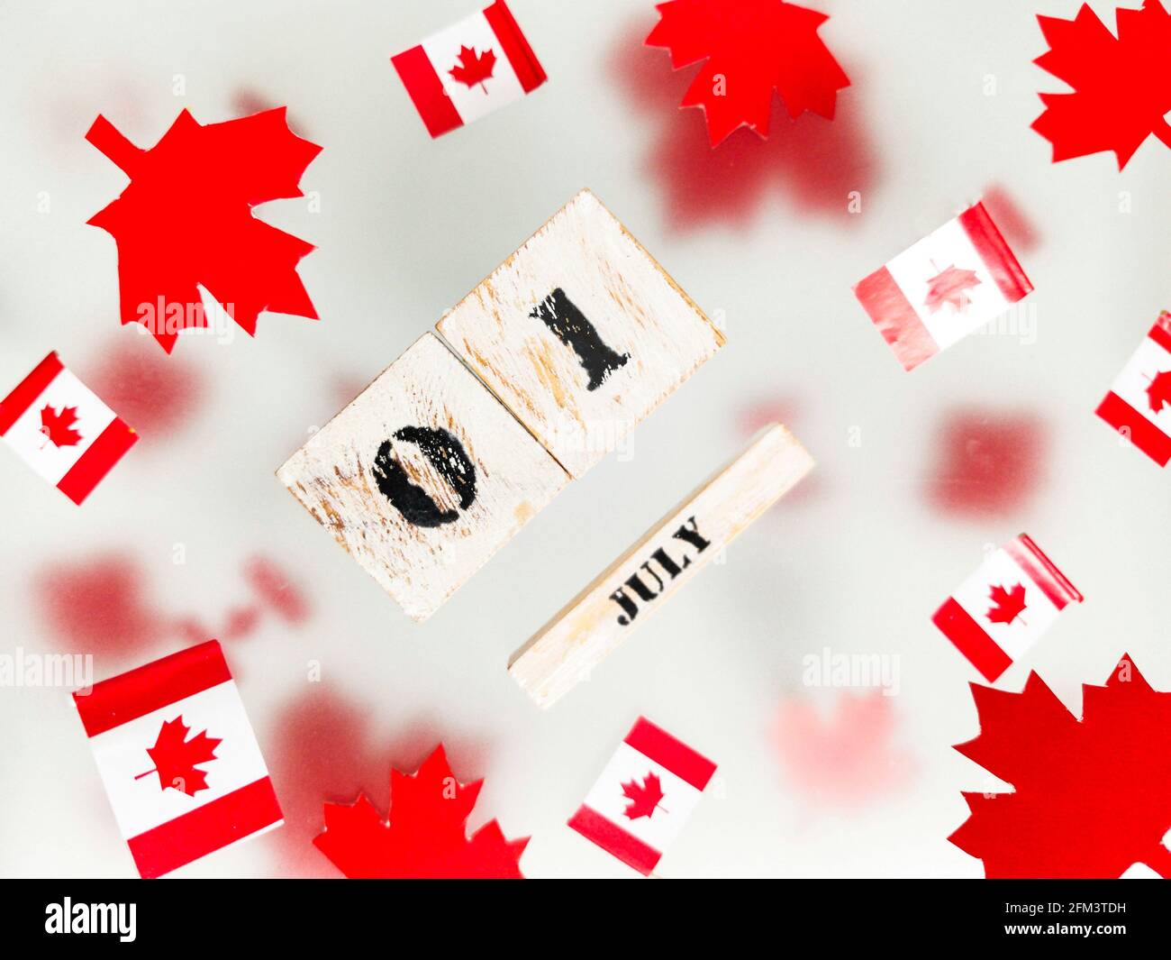 1 luglio, Happy Canada Day. Foglie di acero rosso e bandiere su uno sfondo trasparente foggy. Una foto a più livelli, una carta giorno del Memoriale. Il concetto di libero Foto Stock