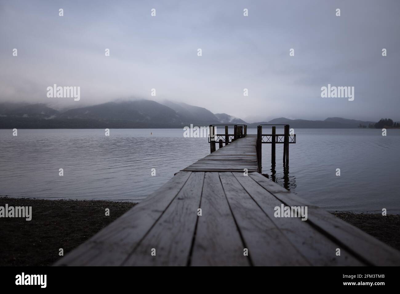 Guardando lungo un Jetty di legno su UNA mattina di Bleak, te Anau, Isola del Sud, Nuova Zelanda Foto Stock