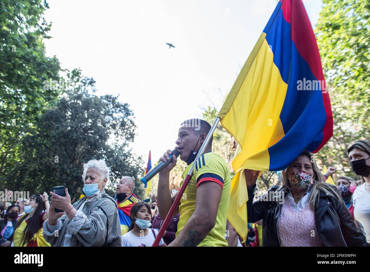 Un manifestante parla attraverso un microfono mentre tiene una bandiera colombiana durante la dimostrazione.circa 400 persone, provenienti soprattutto dalla comunità colombiana di Barcellona, hanno dimostrato un'altra giornata a sostegno dello 'sciopero civico indefinito', Le manifestazioni che hanno riempito le città della Colombia per giorni contro le politiche del presidente Ivan Duque Marquez, che includono la riforma del lavoro, la riforma sanitaria, la riforma delle pensioni e una giustizia della domanda per i quasi mille casi di abusi di polizia registrati durante le marce negli ultimi giorni. Foto Stock