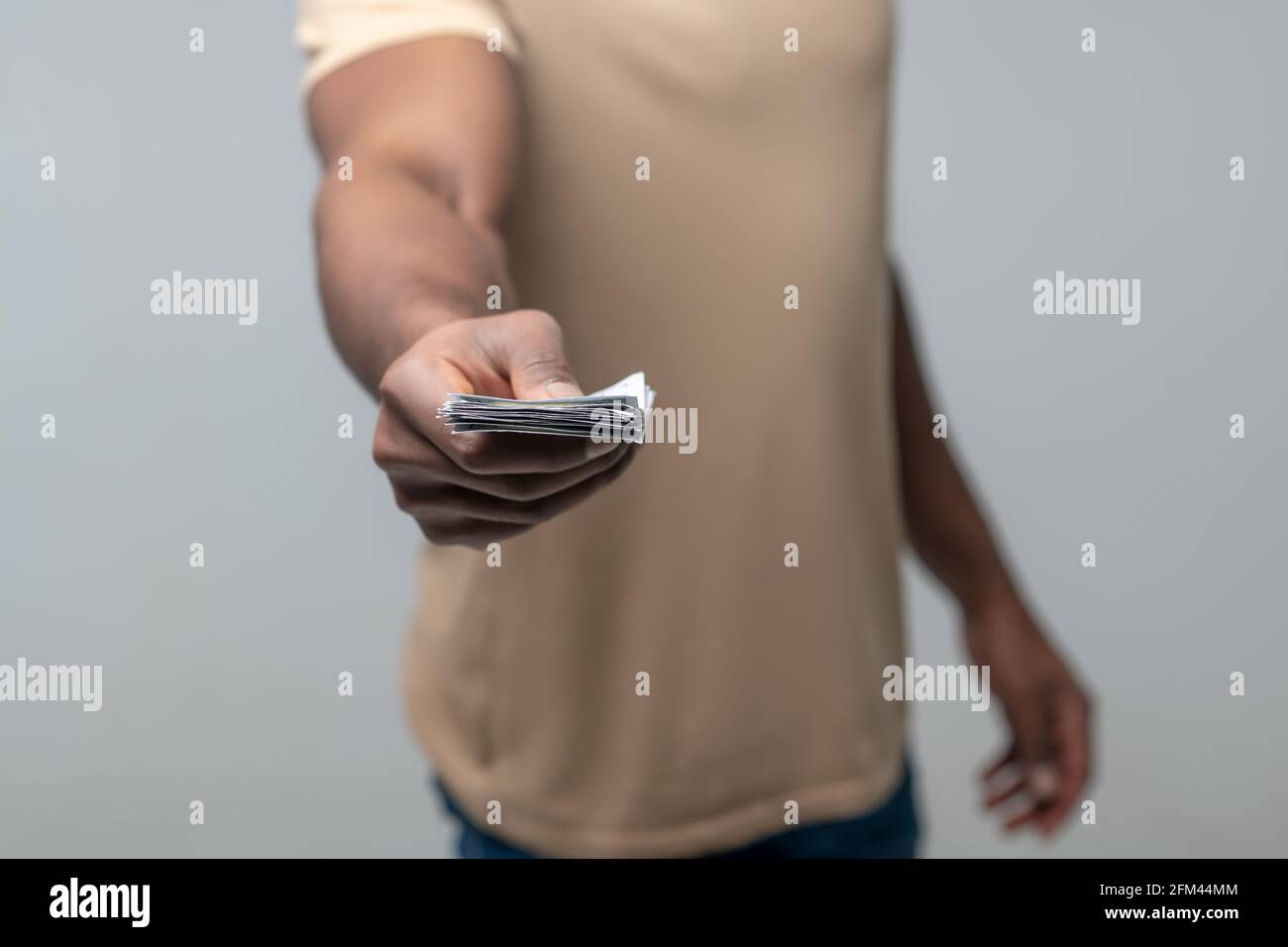 Mano maschile con banconote allungate in avanti Foto Stock