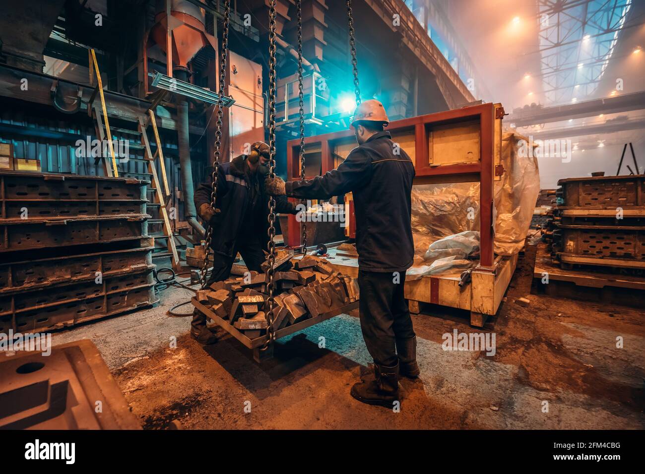 Lavoratori dell'industria pesante in interni di fonderie di acciaierie, sicurezza sul lavoro e lavoro di squadra nell'industria metallurgica. Foto Stock