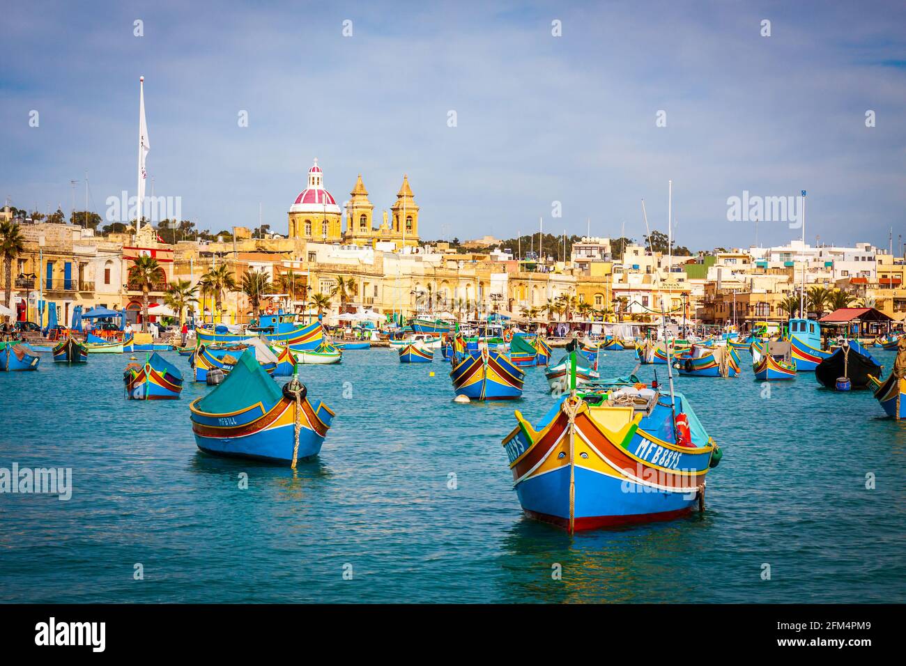 malta - porto di marsaxlockk pieno di barche tipiche chiamato luzzu Foto Stock