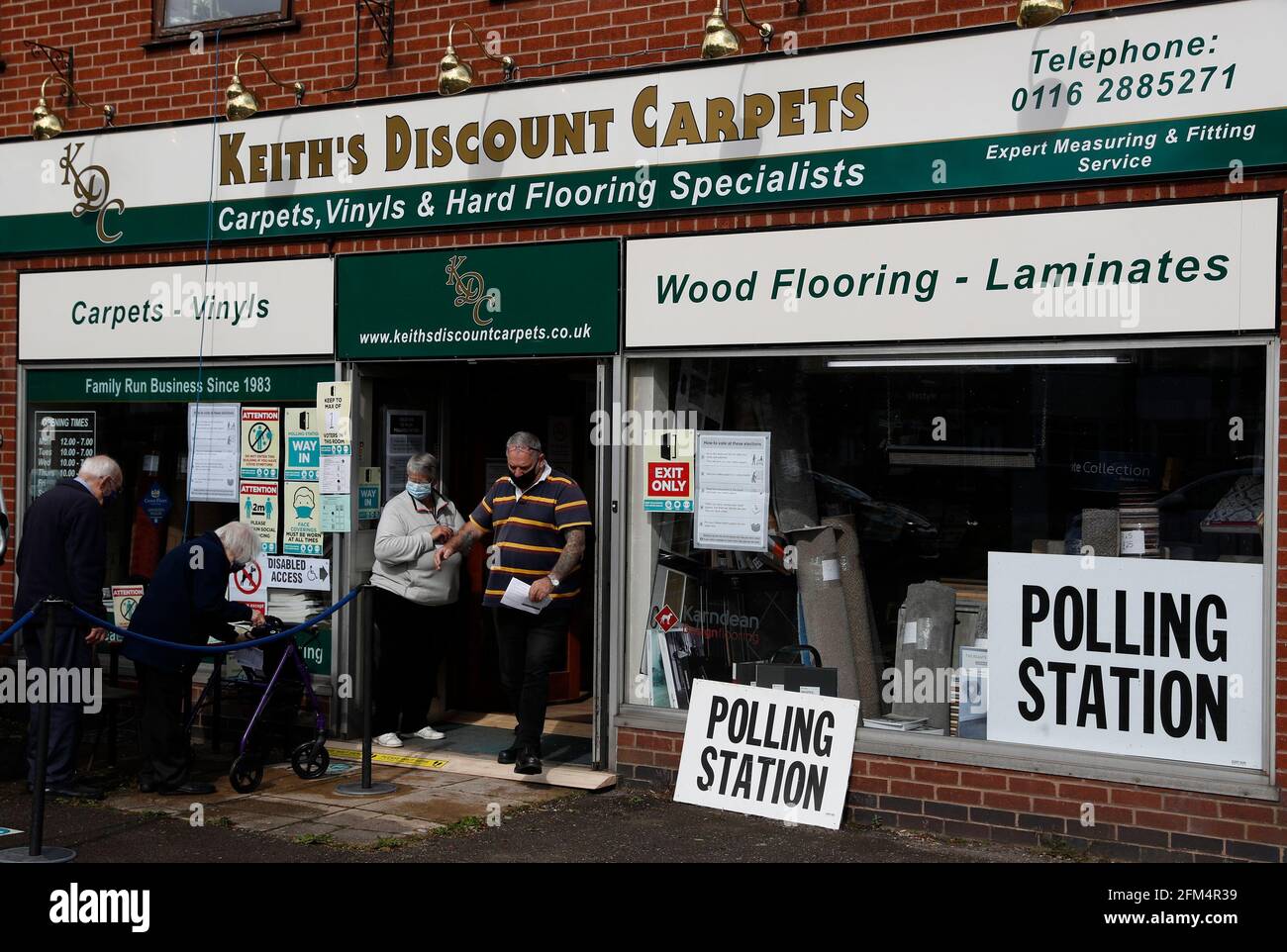 Wigston, Leicestershire, Regno Unito. 6 maggio 2021. Gli elettori entrano in una stazione di polling in un negozio di tappeti durante le elezioni locali. Milioni di persone in tutta la Gran Bretagna faranno uno scrutinio giovedì nella più grande serie di voti dalle elezioni generali del 2019. Credit Darren Staples/Alamy Live News. Foto Stock