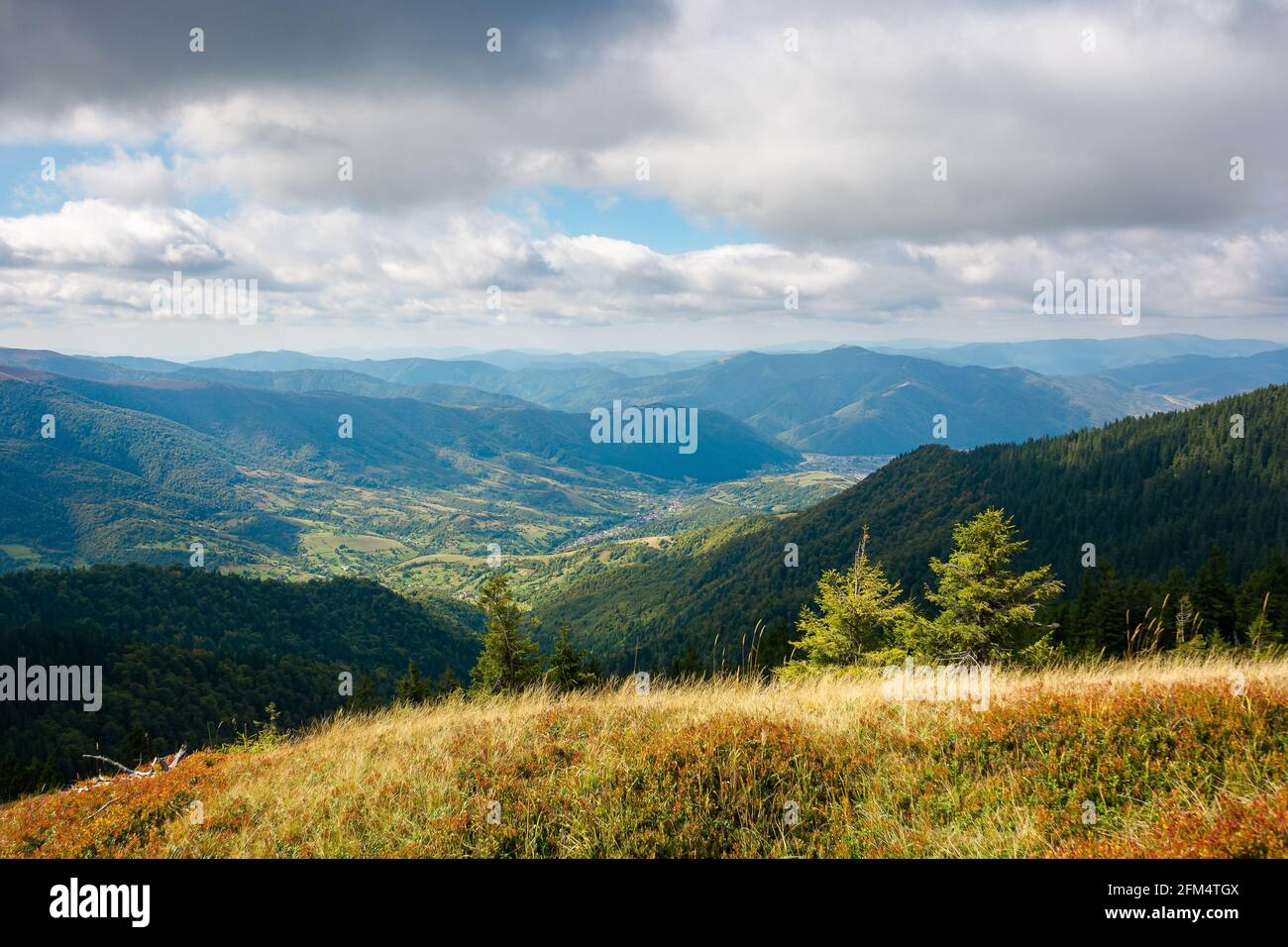 paesaggio montano in autunno. erba sulla collina. vista sulla montagna lontana alla luce del mattino. meraviglioso paesaggio naturale in autunno. nuvole sulla th Foto Stock