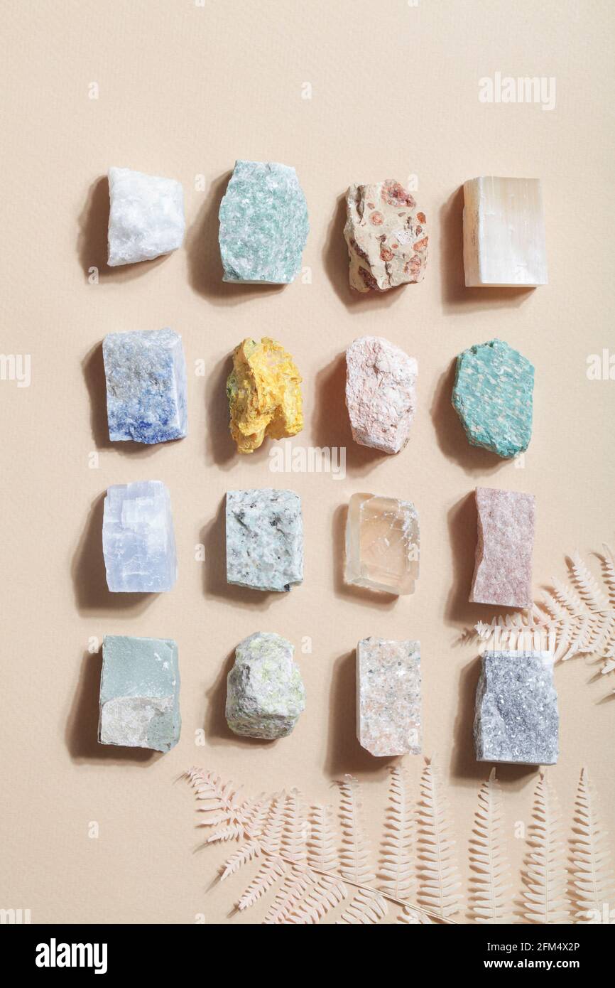 molti minerali cristallini con felce secche su sfondo beige. roccia magica per rituale cristallo, stregoneria, pratica spirituale e meditazione Foto Stock