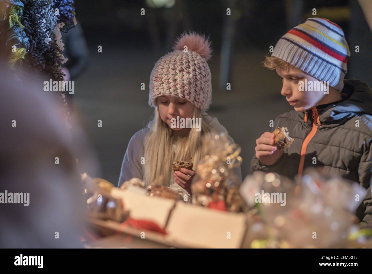 DOMZALE, SLOVENIA - 23 Dic 2018: Giovane famiglia con bambini che acquista allo stand di Natale la fredda sera di dicembre Foto Stock