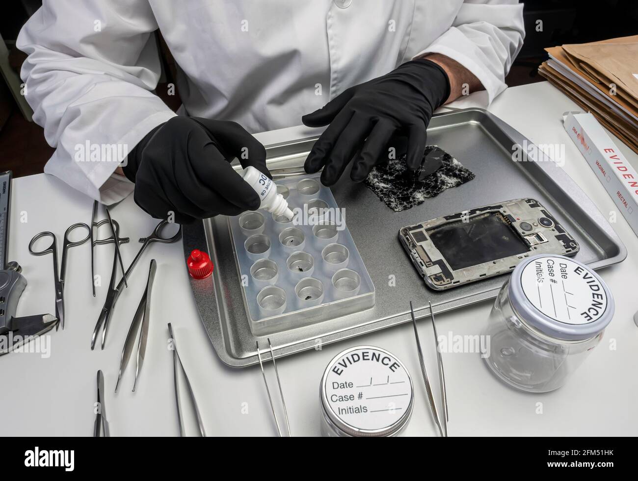 La polizia specializzata indaga i frammenti di smartphone nel laboratorio di criminalità, immagine concettuale Foto Stock