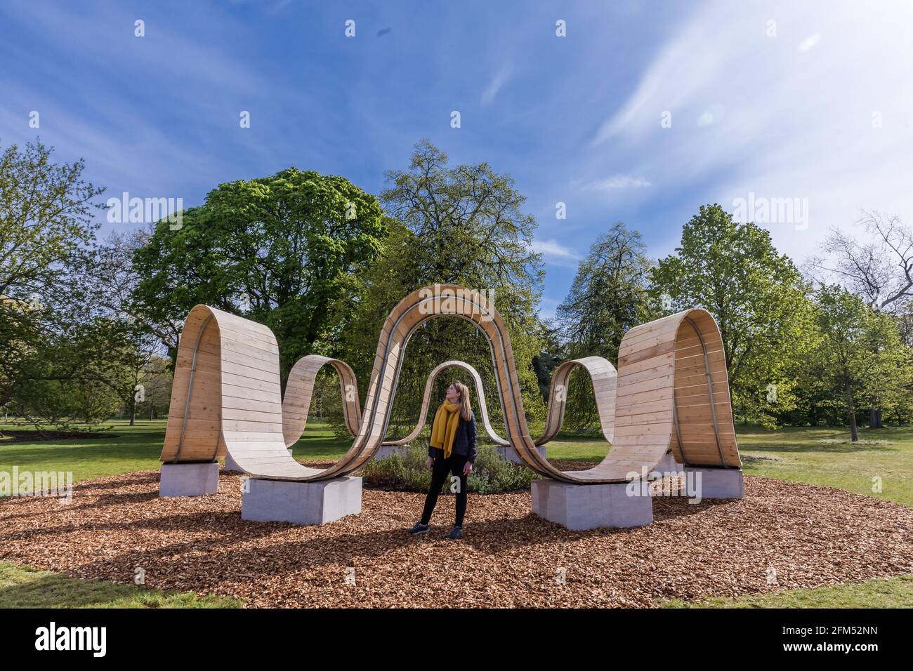 Kew Gardens, Richmond, Regno Unito. 6 maggio 2021. Estate al Kew: Mondo segreto delle piante. Il modello gode della scultura immersiva "Please be seded" di Paul Cocksedge. Il coinvolgente festival estivo abbraccia il meraviglioso mondo della biodiversità vegetale attraverso installazioni d'arte interattive di recente commissionate che utilizzano musica, suoni e colori. Al centro del festival ci sono sei enormi ‘plantscapes’ sparsi in tutti i Kew Gardens che celebrano la biodiversità britannica e avvertono del suo declino. Amanda Rose/Alamy Live News Foto Stock