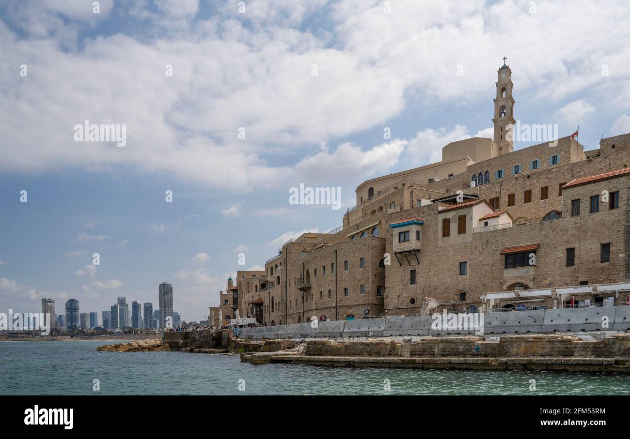 Gli edifici affollati della vecchia città di mare, Jaffa, Israele, e gli scraper del cielo del suo vicino Tel Aviv, come visto dal mare mediterraneo, su una pa Foto Stock