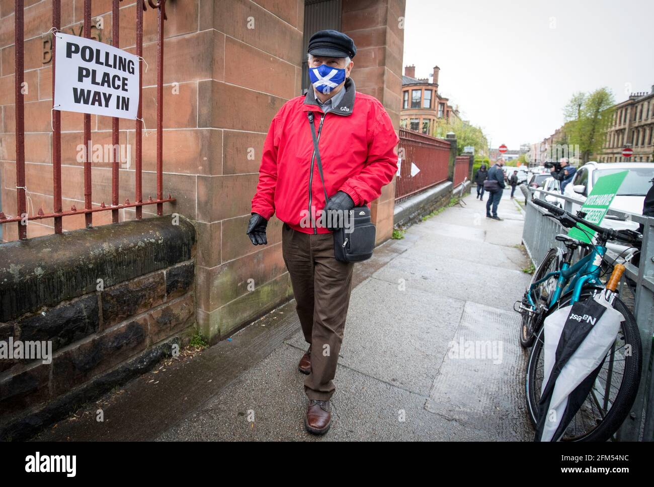 Un elettore che indossa un facemask di protezione del salvataggio lascia la stazione di polling alla scuola elementare di Notre Dame a Glasgow. Data immagine: Giovedì 6 maggio 2021. Foto Stock