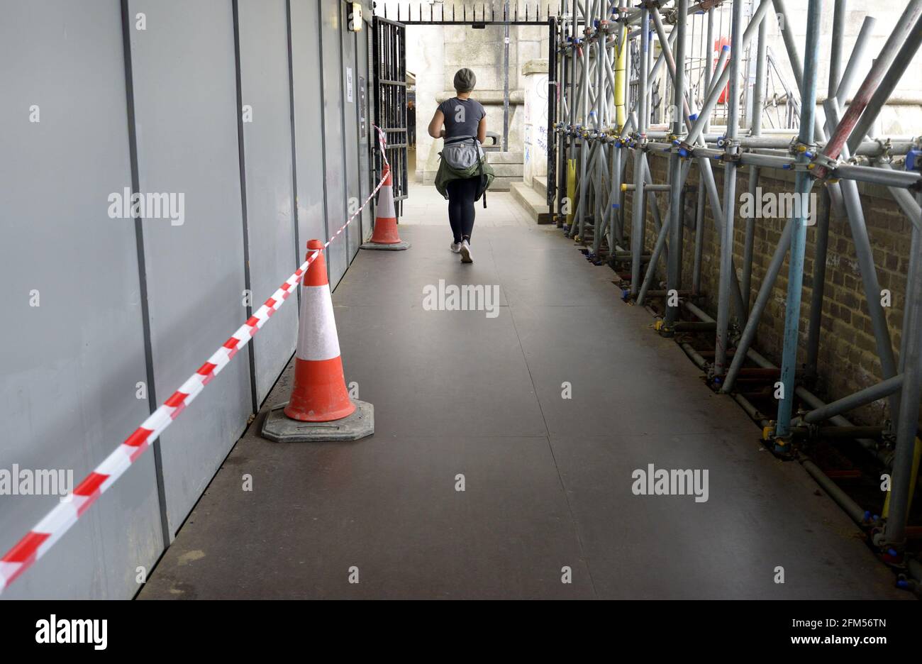Londra, Inghilterra, Regno Unito. Donna che fa jogging da sola attraverso lavori di costruzione sulla South Bank Foto Stock