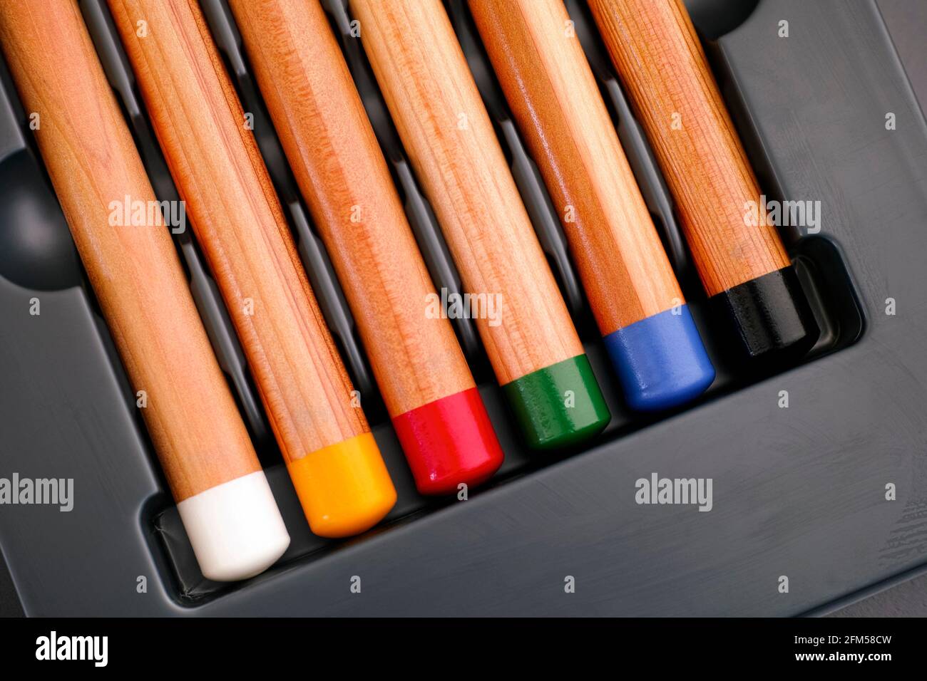 Fondo di sei matite colorate in vassoio grigio primo piano Foto Stock
