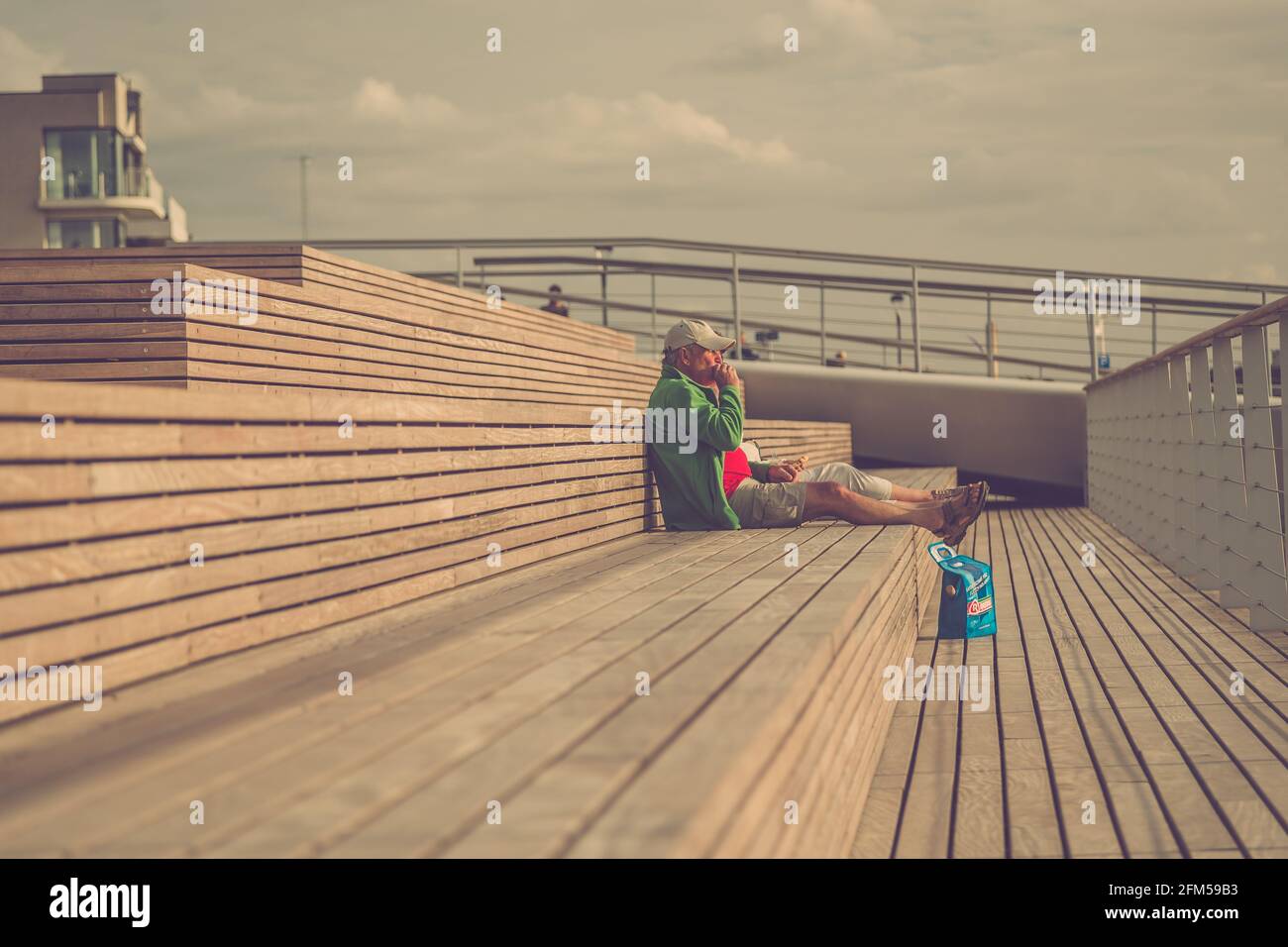 le coppie più anziane si rilassano su una terrazza marina che si affaccia sul mare, facendo uno spuntino in estate Foto Stock