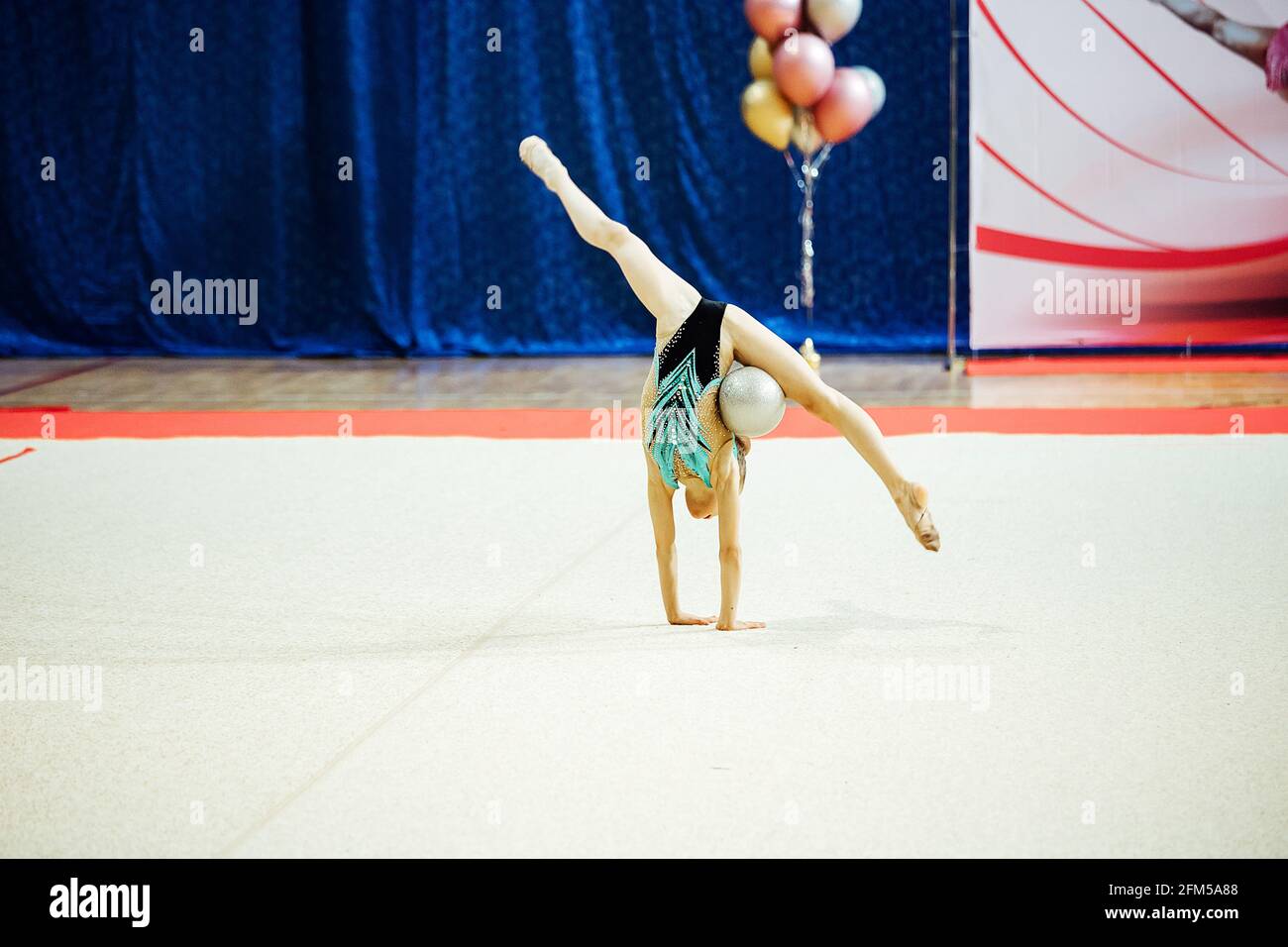 una ragazza ginnastica si esibisce con un cerchio. un atleta flessibile esegue un cavalletto alle competizioni Foto Stock