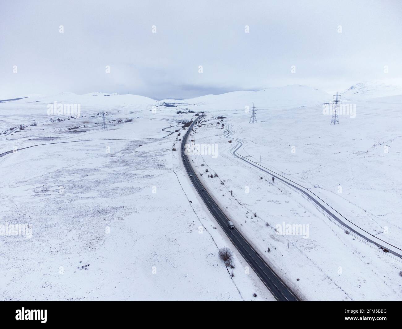 Dalwhinnie, Scozia, Regno Unito. 6 maggio 2021. Vista aerea del paesaggio innevato nel Passo di Drumochter ad alta quota a Dalwhinnie nelle Highlands scozzesi. PIC; l'autostrada A9 si snoda verso nord attraverso un Passo Drumochter coperto di neve. Iain Masterton/Alamy Live News Foto Stock