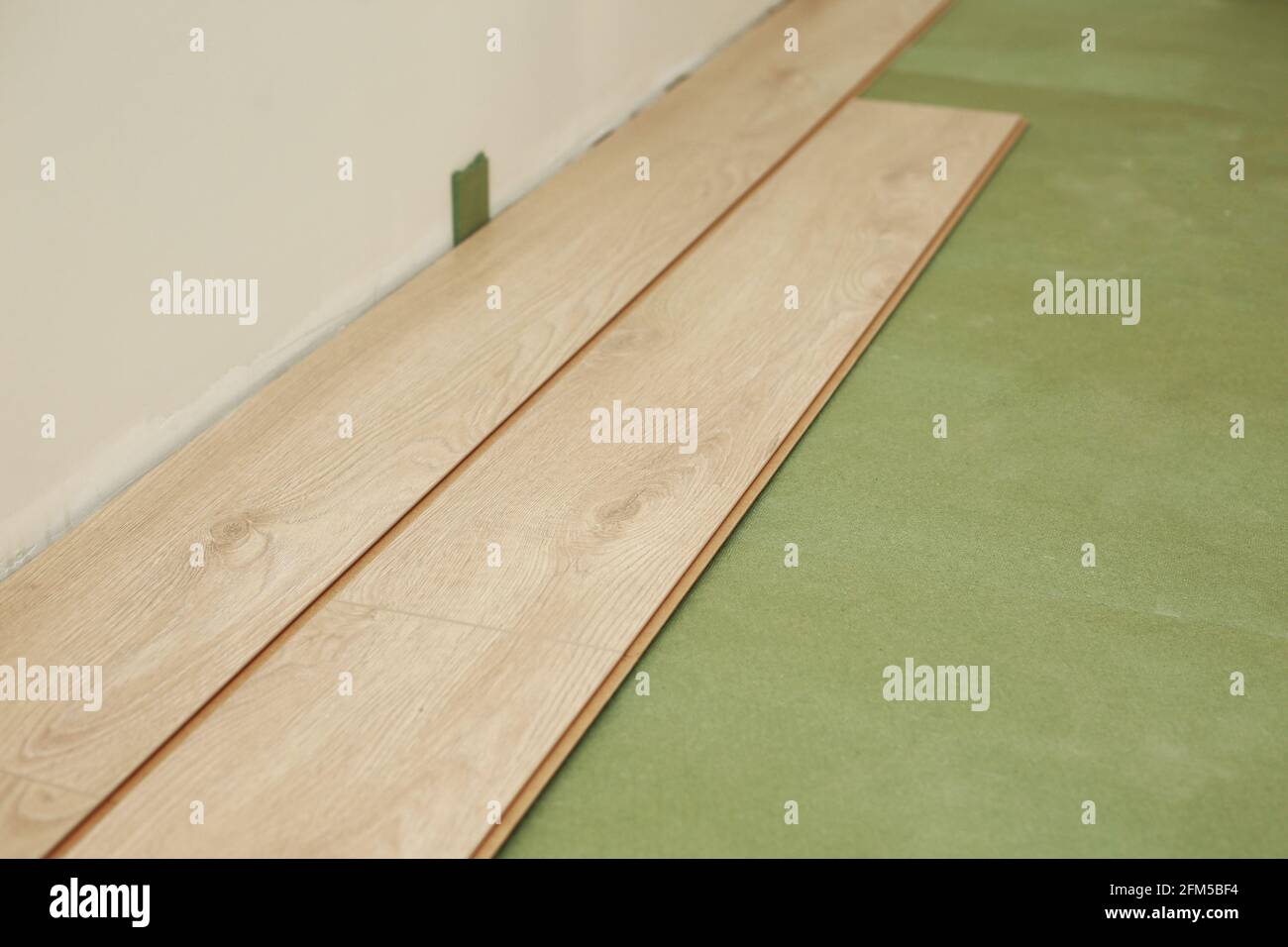Installazione di pavimenti in legno laminato o parquet in camera su base  verde. Montaggio dei pannelli in modo rapido e semplice - pavimento a  prezzi accessibili. Posa in laminato Foto stock - Alamy