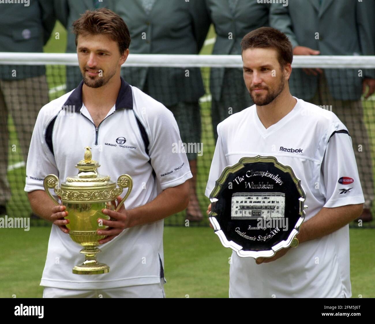 WIMBLEDON MENS FINALE PAT RAFTER V GORAN IVANISEVIC DOPO IL LA PARTITA ERA FINITA CON I GIOCATORI CHE TENEVANO I LORO TROFEI Foto Stock