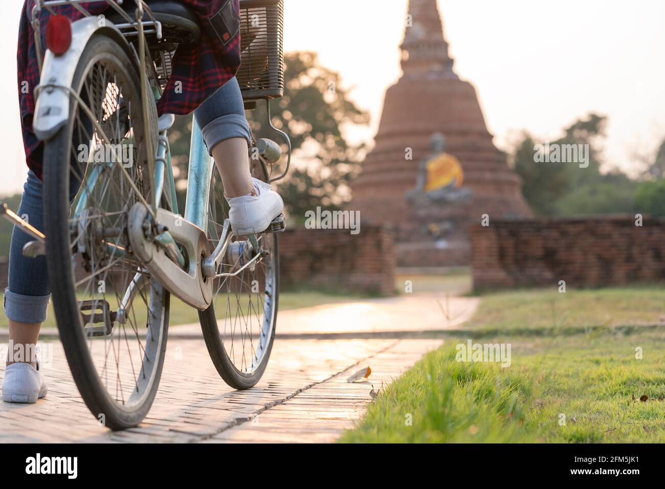 Donna turista che cavalcano una bici turistica in un vecchio tempio in Thailandia. Foto Stock