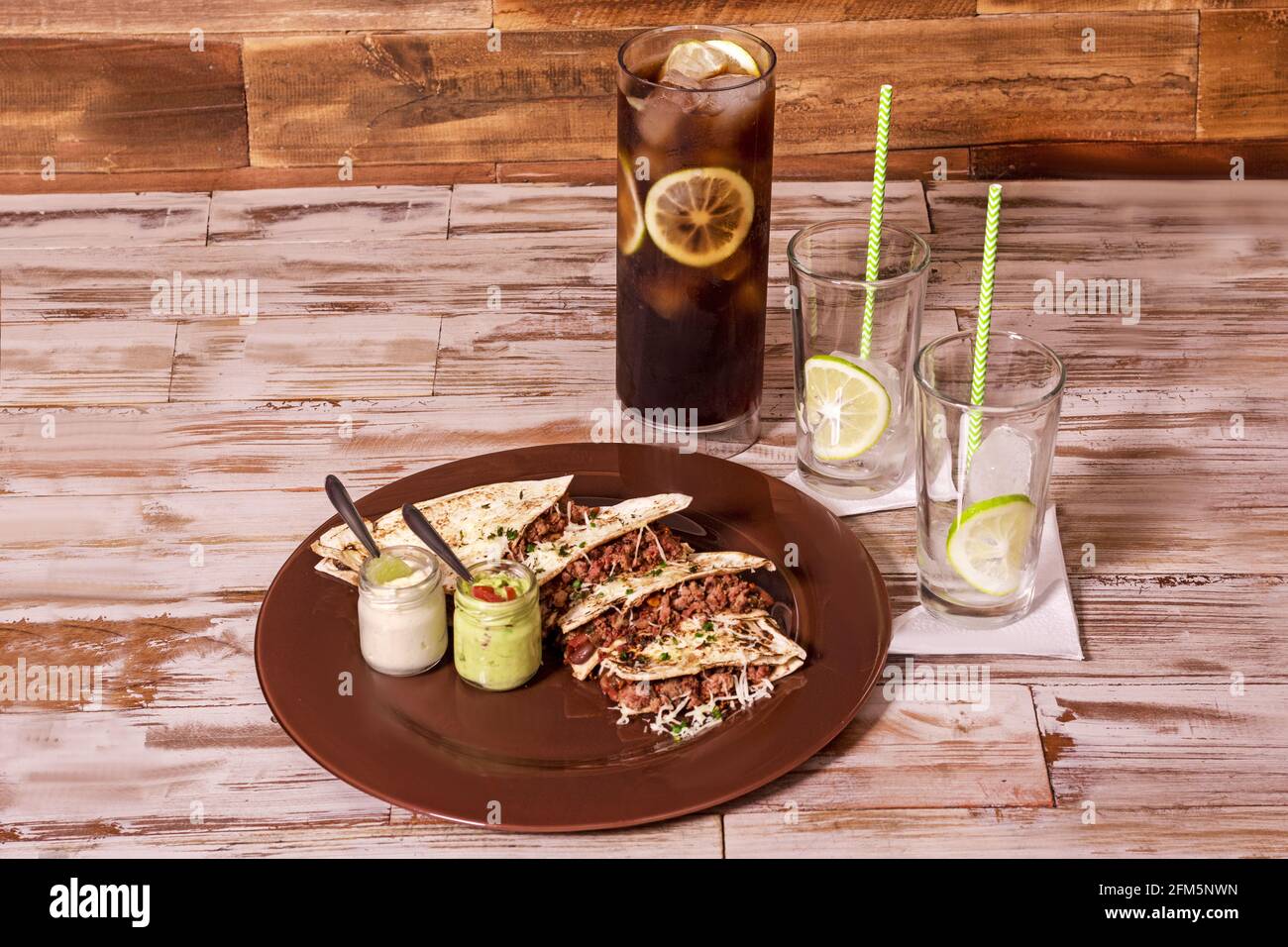 Porzione di quesadilla e caraffa di soda in due bicchieri Foto Stock