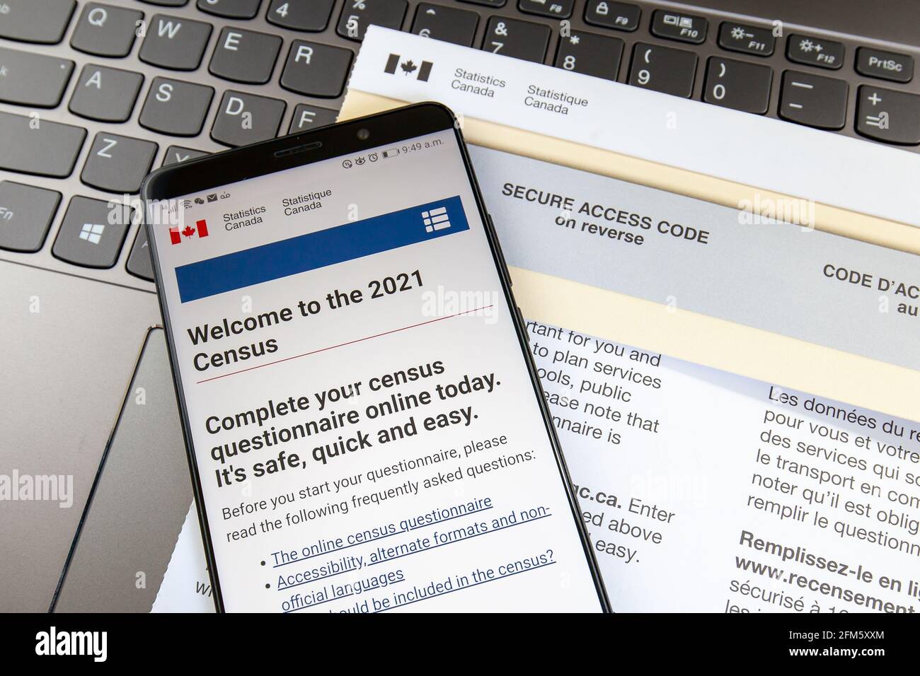 Toronto, Canada - 6 maggio 2021: Uno smartphone che mostra la home page del sito del censimento del Canada 2021 sulla lettera con il codice di accesso sicuro con una tastiera i Foto Stock