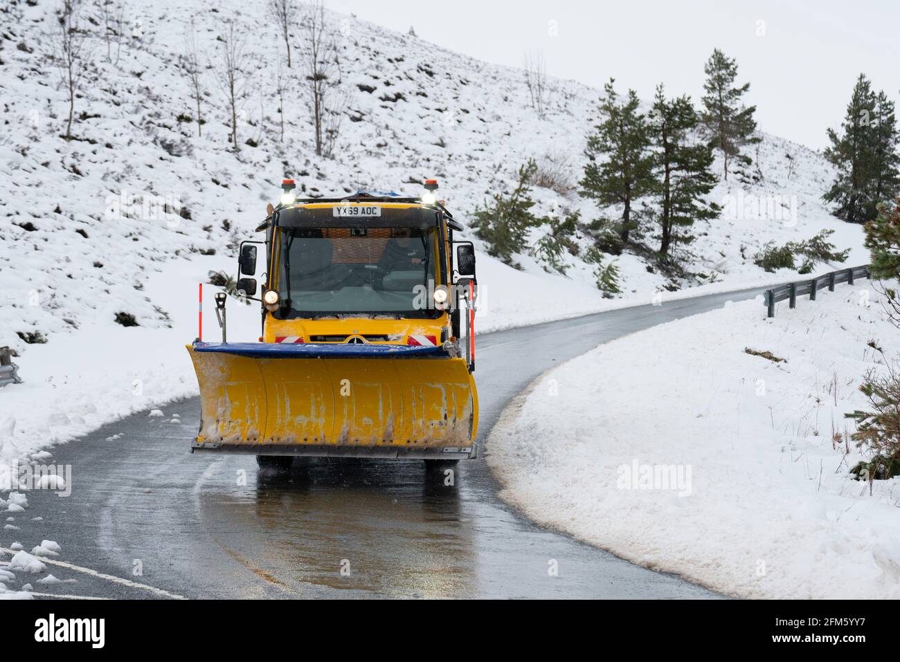 Aviemore, Scozia, Regno Unito. 6 maggio 2021. Le forti nevicate notturne nel Cairngorms National Park hanno dato un'occhiata instagionale al paesaggio. Gli appassionati di alpinismo hanno ottenuto il massimo dalle condizioni nonostante le seggiovie fossero chiuse. Ciò significava lunghe passeggiate sulle piste prima di sciare in discesa. PIC; spazzaneve che scola la strada di accesso al Centro sciistico di Cairgorm. Iain Masterton/Alamy Live News Foto Stock