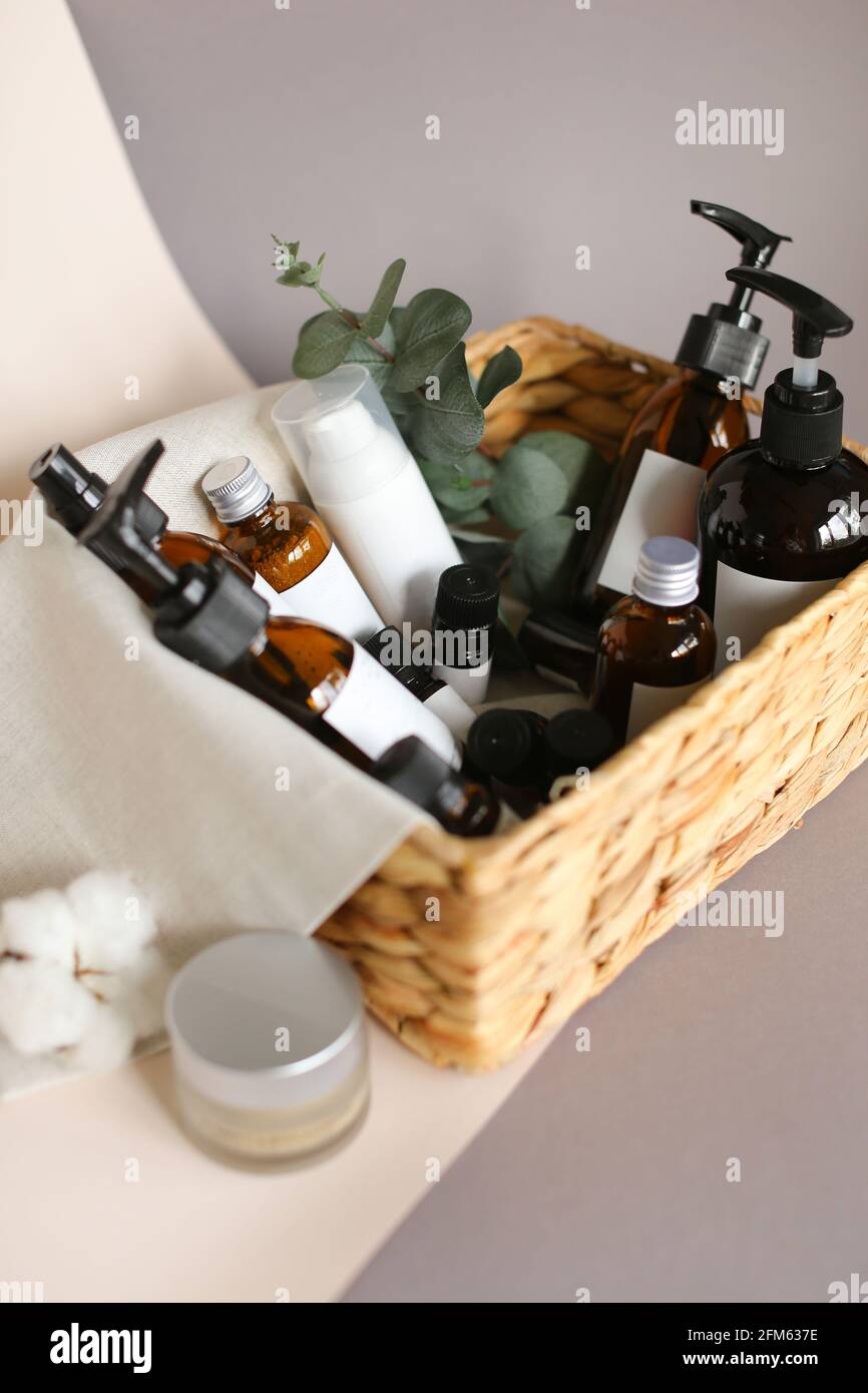 raccolta di vari tubi per l'igiene della bellezza, bottiglie e vasetti in cestello su sfondo grigio Foto Stock