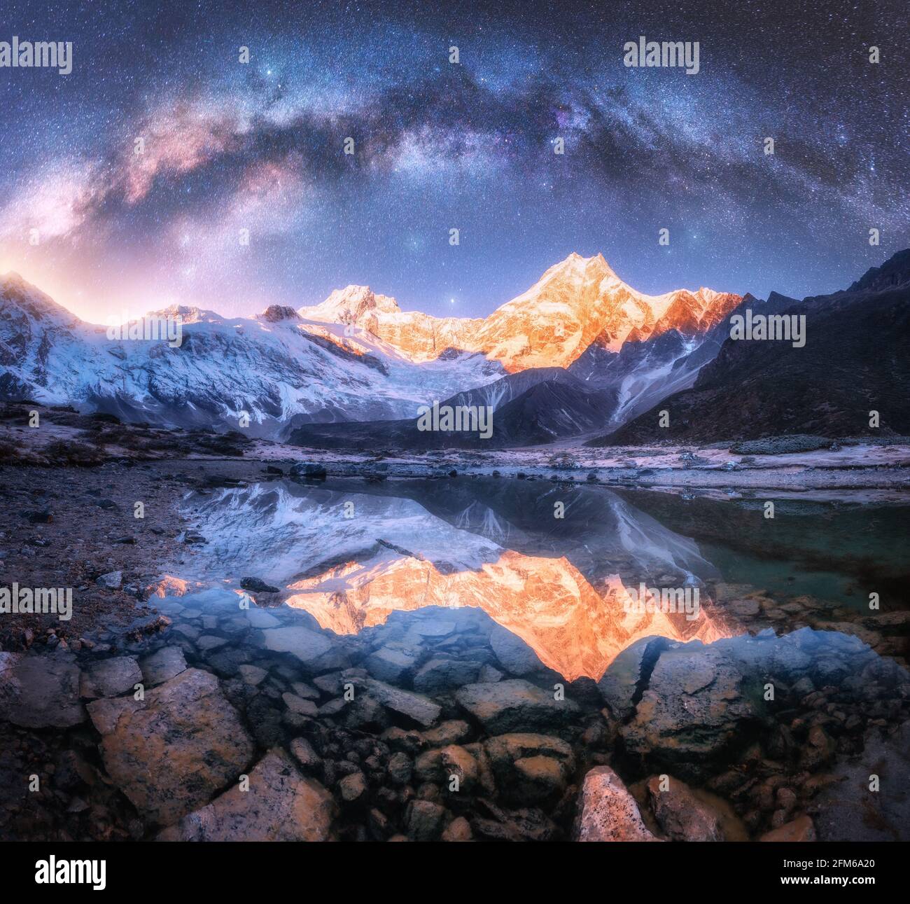 Milky Way su montagne innevate e lago di notte. Orizzontale Foto Stock