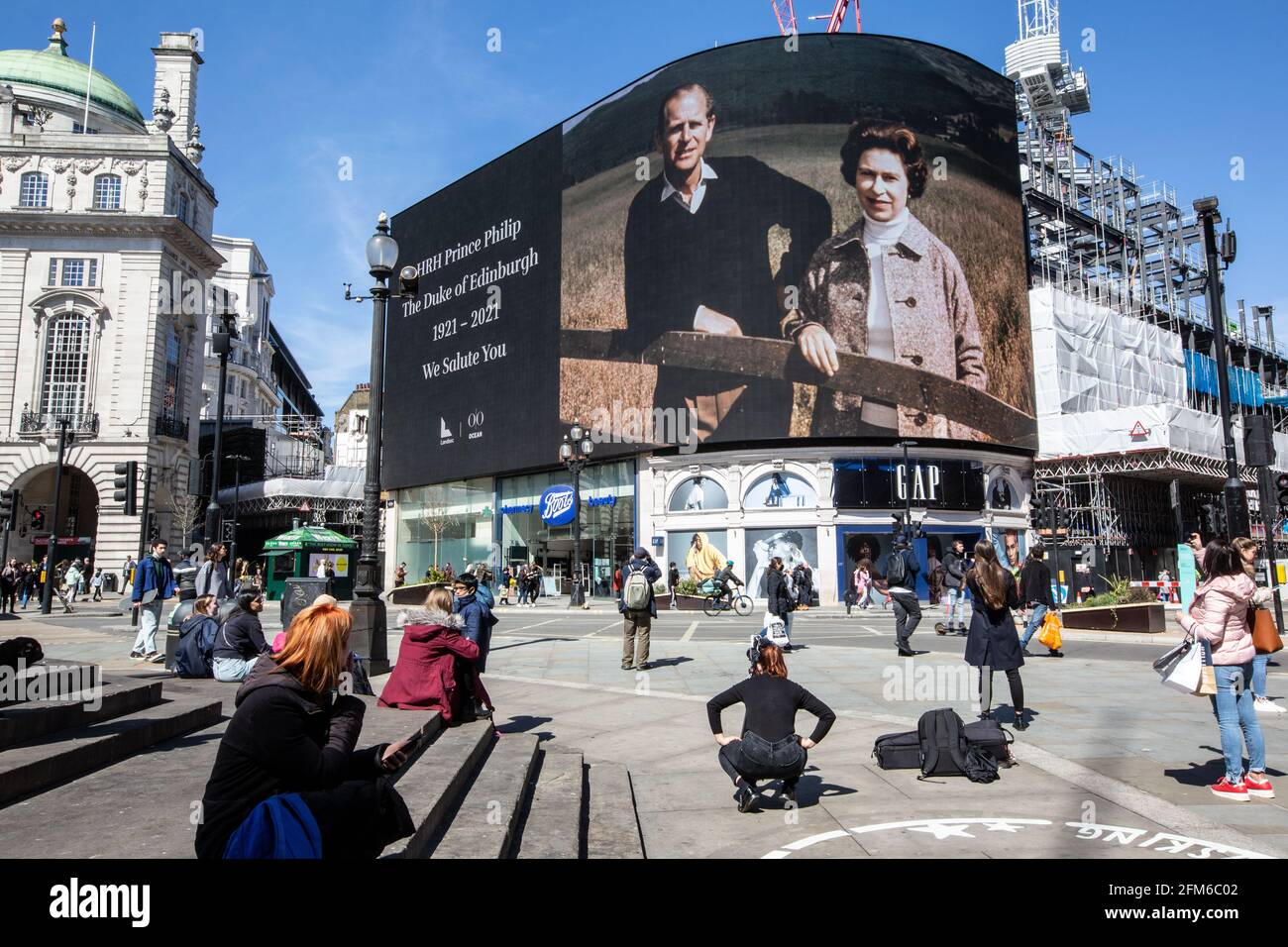 La gente si ferma a guardare il famoso schermo pubblicitario a Piccadilly Circus come ha mostrato un tributo per il principe Filippo, il giorno del suo funerale, Regno Unito Foto Stock