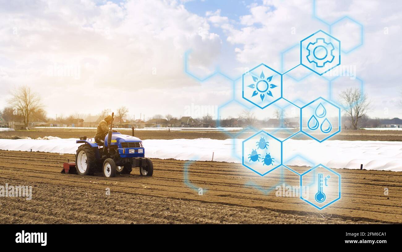 Coltivatore su un trattore con fresatrice allenta, macina e mescola il terreno. Startup agricole, miglioramenti, digitalizzazione dell'industria agricola. Inn Foto Stock