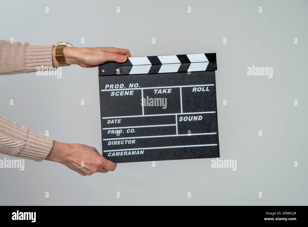 Inghilterra, Regno Unito. 2021. Le mani della donna che reggono un pannello di clapper usato per registrare nei particolari di produzione del gesso bianco nelle riprese. Foto Stock