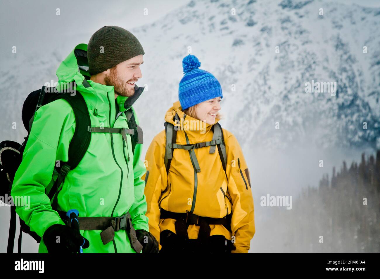 Coppia che indossa giacche invernali in un ambiente montano all'aperto. Foto Stock