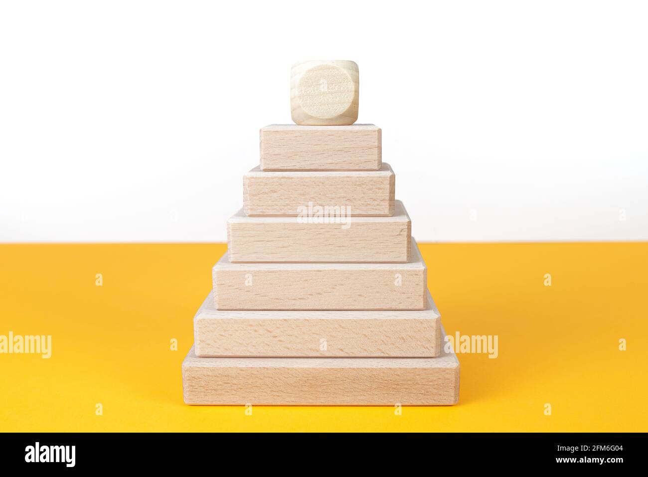 vista ravvicinata della piramide in blocchi di legno con spazio per la copia scrivania arancione Foto Stock