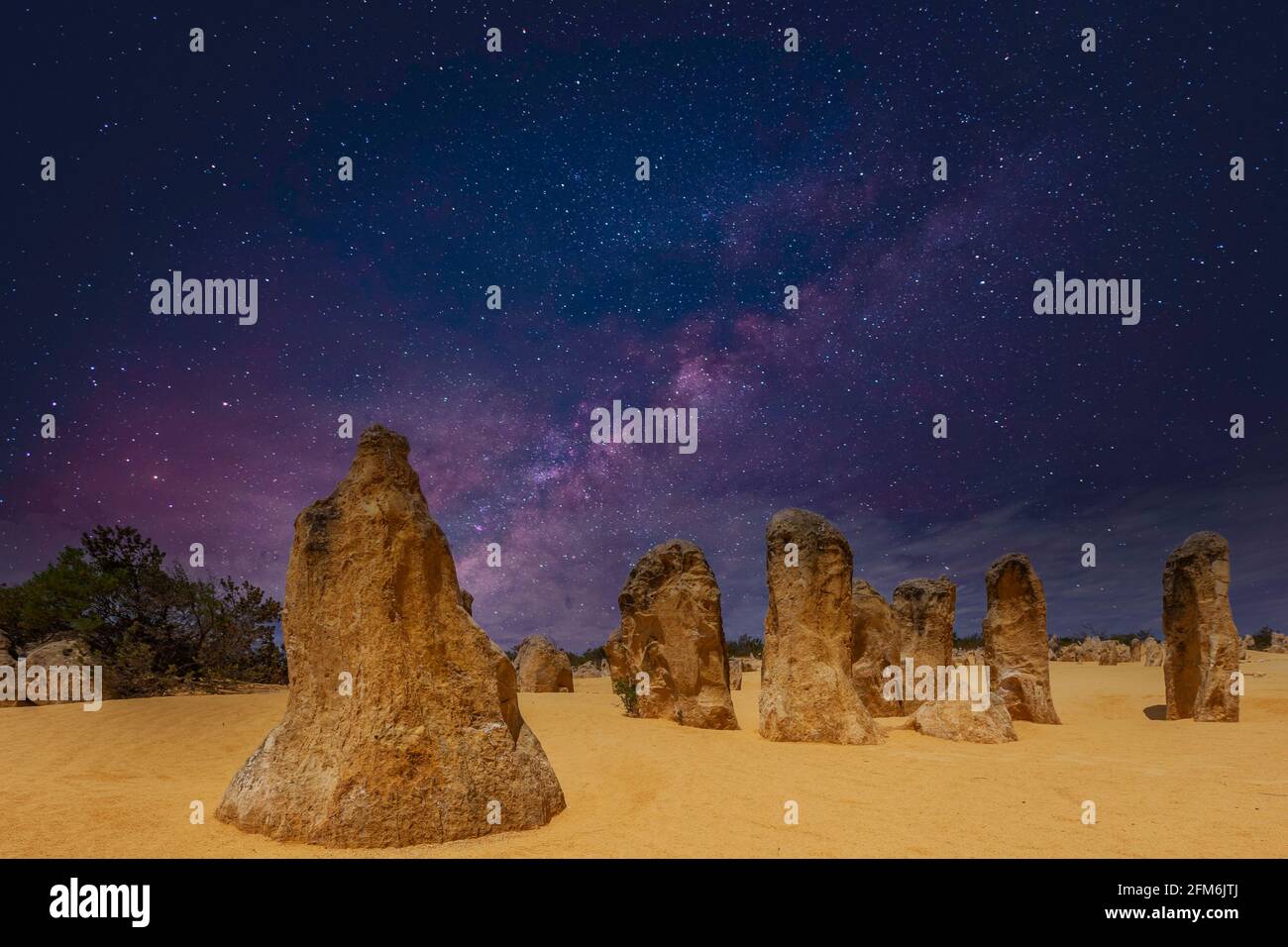 Il cielo stellato sopra i pilastri della pianta fossile rimane i Pinnacoli Nel Parco Nazionale di Nambung in Australia Occidentale con giallo dorato ornamenti sulla fronte Foto Stock