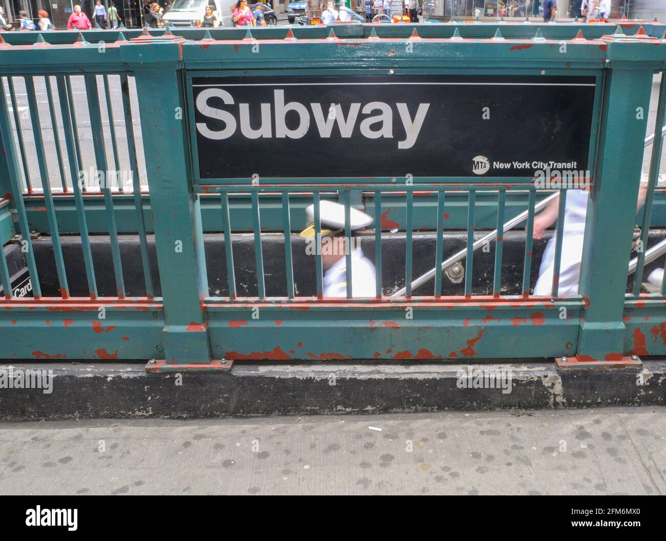 Un uomo della Marina decende le scale del sistema di transito di New York City conosciuto come la metropolitana. Foto Stock
