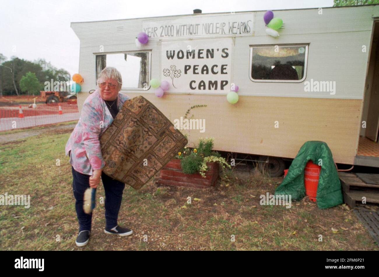 Le donne di Greenham Common finalmente si allontanano dopo 19 anni. Una delle due donne rimanenti, Jean Hutchinson spazzolando un tappetino prima della rimozione della caravan. Foto Stock